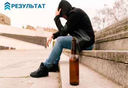 Алкоголик сидит на уличной лестнице