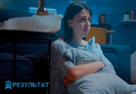 Грустная женщина сидит в кровати
